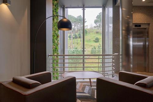 a room with two chairs and a table and a window at Hotel Versatile in Guarda