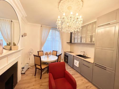 a kitchen with a dining table and a chandelier at The Hyde Park Suites in London
