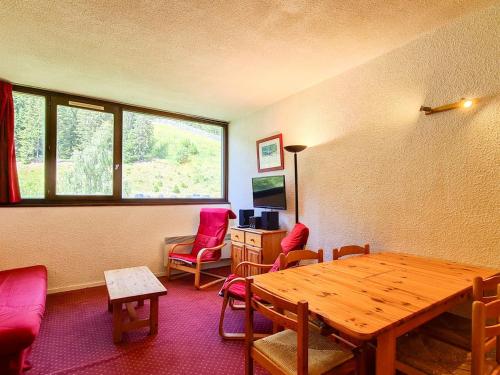 un salon avec une table et des chaises en bois dans l'établissement Studio confortable Proche des pistes Casier à ski - FR-1-425-79, à Flaine