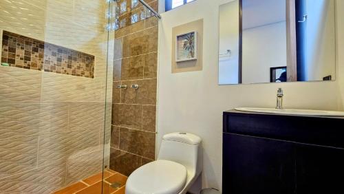 ein Bad mit einem WC und einer Glasdusche in der Unterkunft Casa Quinta 10 Minutos de Villeta in Bagazal