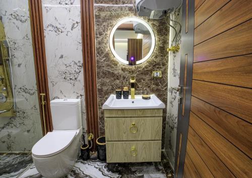 a bathroom with a toilet and a sink and a mirror at Piccolo Mondo Boutique Hotel in Cairo