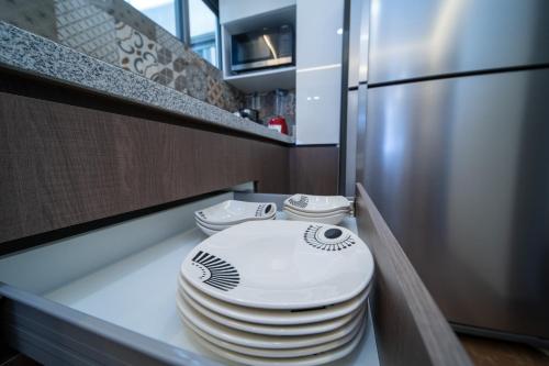 a stack of plates sitting on a counter in a kitchen at Apartamentos Posada Country in Guadalajara