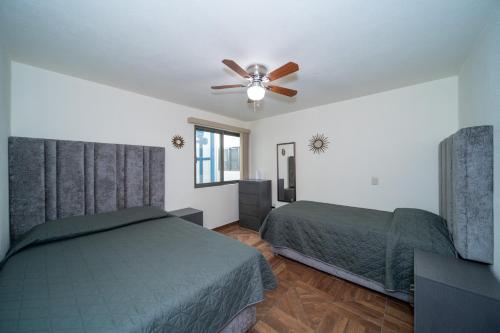 a bedroom with two beds and a ceiling fan at Apartamentos Posada Country in Guadalajara