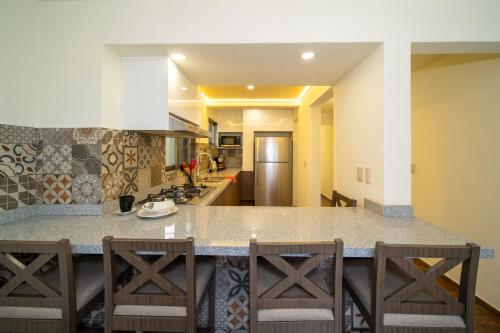 a kitchen with a counter and some chairs in it at Apartamentos Posada Country in Guadalajara