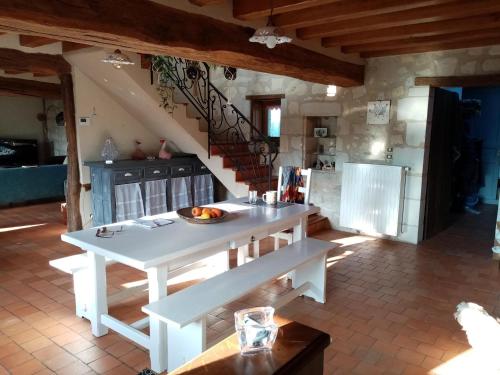 une cuisine avec une table blanche et un escalier dans l'établissement Le clos champêtre, à Longué