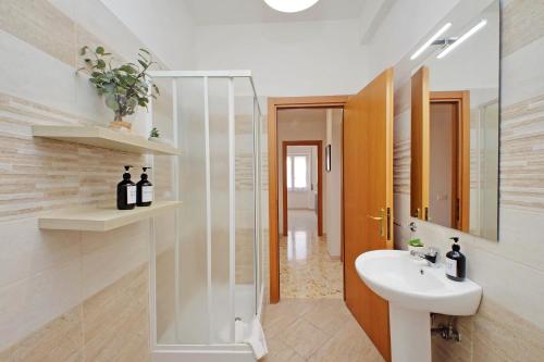 a bathroom with a sink and a mirror at Ampio con ottimi collegamenti per Roma & Aeroporto in Fiumicino