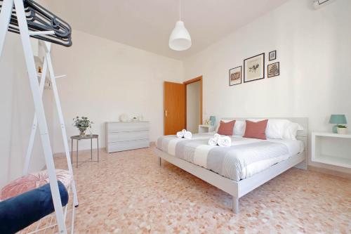 a white bedroom with a bed and a ladder at Ampio con ottimi collegamenti per Roma & Aeroporto in Fiumicino