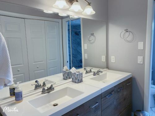 a bathroom with two sinks and a large mirror at A home away from home in Orlando