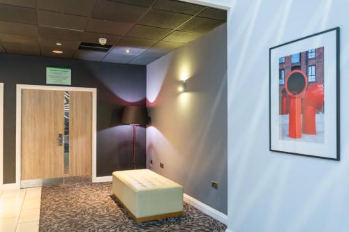 a waiting room with a bench and a painting on the wall at Holiday Inn Liverpool City Centre by IHG in Liverpool