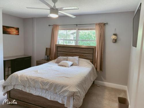 a bedroom with a bed with a ceiling fan at A home away from home in Orlando