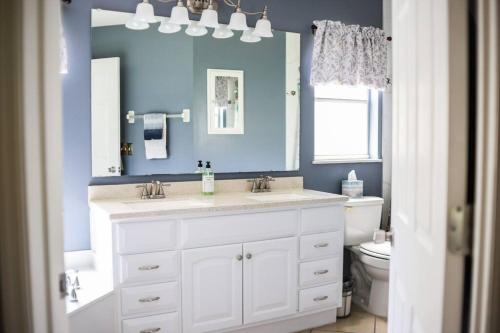 ein Badezimmer mit einem weißen Waschbecken und einer blauen Wand in der Unterkunft NEW Disney World Villa 4BR, Private Pool Fam Retreat in Davenport