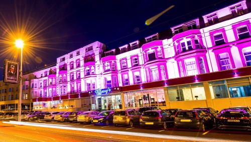 a row of cars parked in front of a building with purple lights at Tiffany's Hotel in Blackpool
