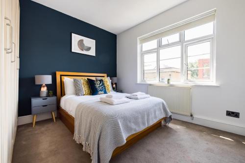 a bedroom with a bed with a blue wall at The Tower Bridge Collection in London