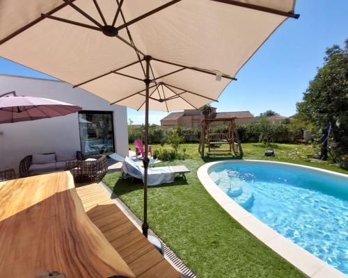 - un parasol au-dessus d'une piscine dans une cour dans l'établissement Chez Cendra, à Borgo