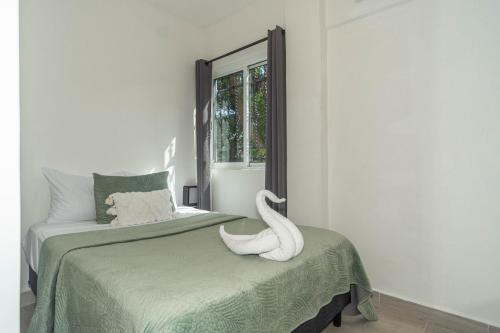 a white swan sitting on a bed in a room at La Quinta Caribeña in Playa del Carmen