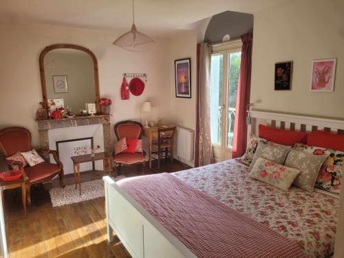 a bedroom with a bed and a living room with a fireplace at La Roseraie in Neuville-de-Poitou