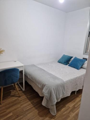 Habitación blanca con cama y escritorio en Quarto com banheiro privado em apartamento familiar, en Alicante