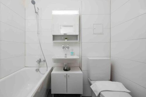 een witte badkamer met een wastafel en een bad bij Urban Oasis with Queen Bed and View BE-42 in Zürich