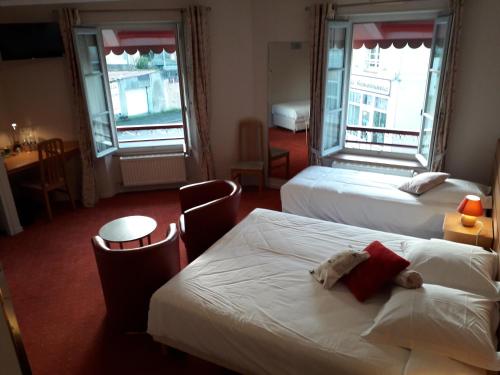 a hotel room with two beds and a teddy bear on the bed at Logis La Renaissance in Le Lude