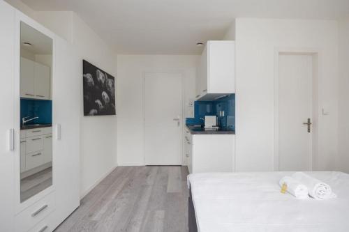 a white room with a bed and a kitchen at Urban Oasis with Queen Bed and View BE-34 in Zürich
