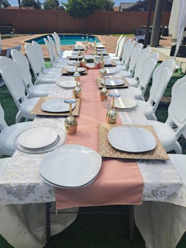 a long table with plates and napkins on it at LOTUS LODGE in Gaborone