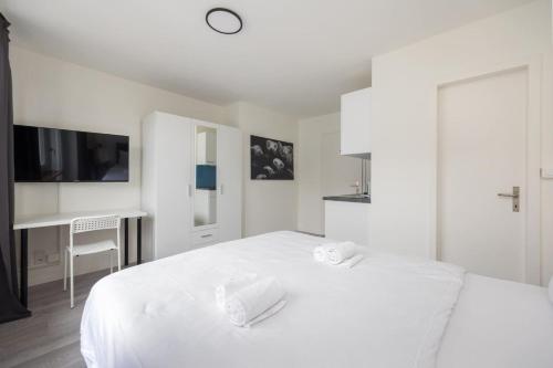 a white bedroom with a white bed and a desk at Urban Oasis with Queen Bed and View BE-44 in Zürich