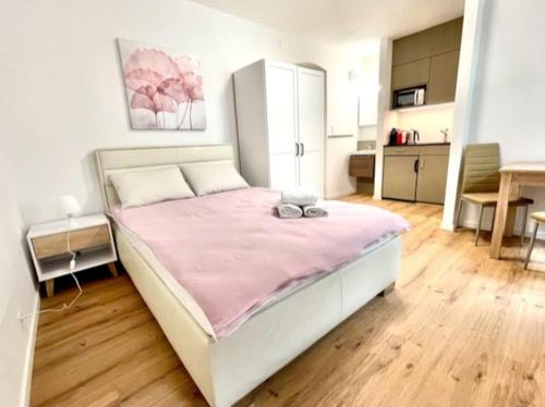 a bedroom with a large bed with a pink blanket at Heart of Zurich Modern Studio HG7 in Zurich