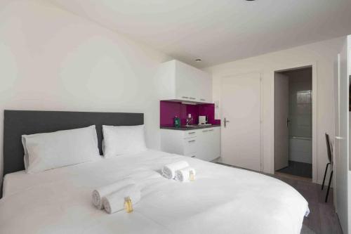 a bedroom with a white bed with two candles on it at Urban Oasis with Queen Bed and View BE-29 in Zürich