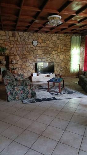 - un salon avec une télévision, un canapé et une table dans l'établissement COLIBRI VILLA 3 ROOMS, à Gisenyi