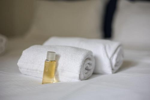 Una botella de jabón en una cama con toallas en Urban Oasis with Queen Bed and View BE-29 en Zúrich