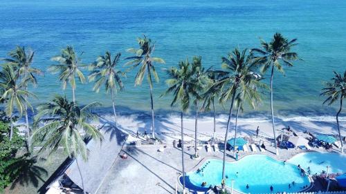 an aerial view of a beach with palm trees and the ocean at Sai Rock Beach Hotel & Spa in Bamburi