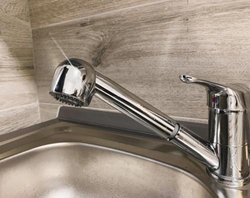 a kitchen sink with a faucet on a counter at Station House in Lido di Ostia