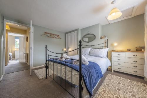 sypialnia z łóżkiem i komodą w obiekcie Poppy Cottage H w mieście Holt