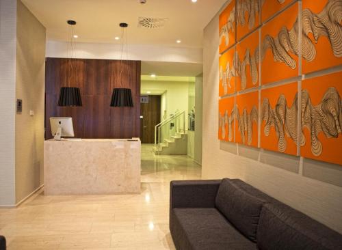 an office lobby with a couch and a desk at Carris Cardenal Quevedo in Ourense