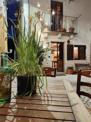 a wooden table with a potted plant on it at Casetta la Crus - Romantic house in Musellaro
