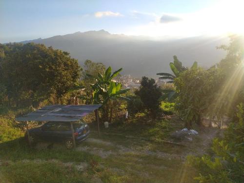 un'auto parcheggiata in un campo con un tetto sopra. di Hospedaje Roca Firme a Choachí