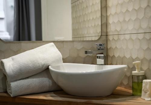 un cuenco blanco sentado en un mostrador en un baño en Celenya Hôtel, en Toulon