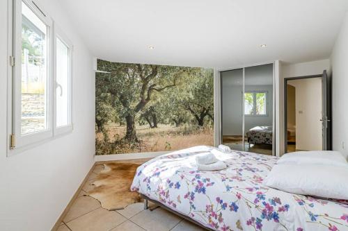 um quarto com uma cama com um quadro na parede em Sunny Dreams : villa de plain-pied, vue mer em La Ciotat