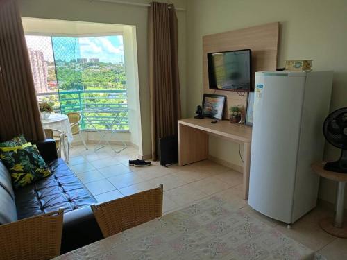 a living room with a couch and a refrigerator at Apartamento em Caldas Novas in Caldas Novas