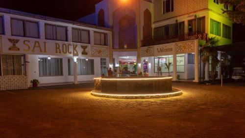 a fountain in the middle of a street at night at Sai Rock Beach Hotel & Spa in Bamburi