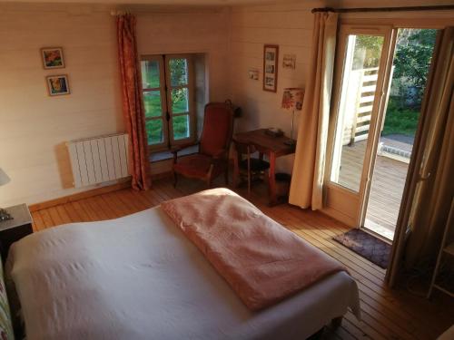 Schlafzimmer mit einem Bett, einem Schreibtisch und Fenstern in der Unterkunft Loge & Broc in La Possonnière