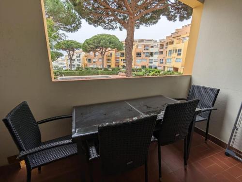 une table et des chaises dans une pièce avec un arbre dans l'établissement CAP2 Studio 3p Parking Port Cap d'Agde, au Cap d'Agde