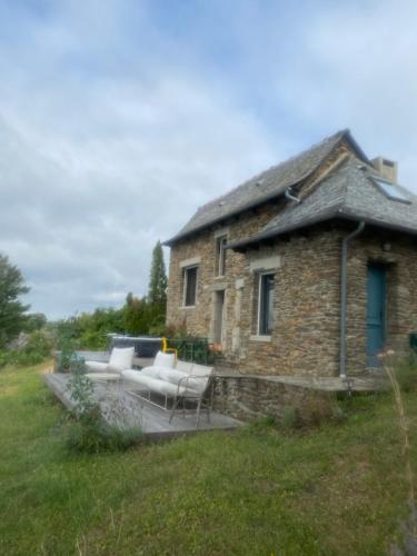 uma casa de pedra com um pátio em frente em La tête dans les nuages em Le Fel