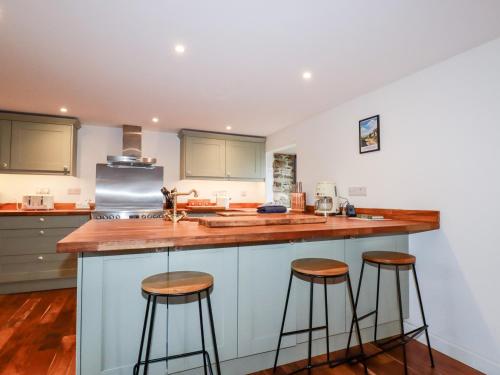 a kitchen with two bar stools and a counter top at The Old Cattle Barn in Launceston