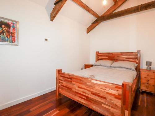 a bedroom with a wooden bed in a room at The Old Cattle Barn in Launceston