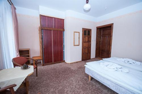a bedroom with two beds and a table and a window at Hotel Narcyz B in Świeradów-Zdrój