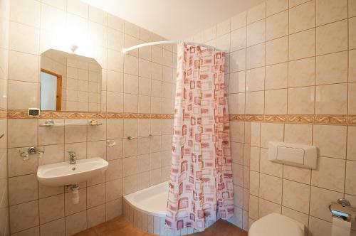 a bathroom with a sink and a shower curtain at Hotel Narcyz B in Świeradów-Zdrój