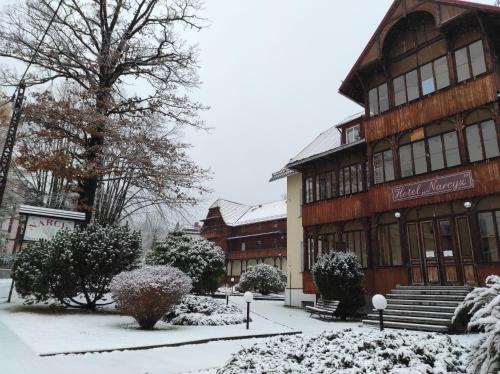 a building with snow on the ground in front of it at Hotel Narcyz B in Świeradów-Zdrój