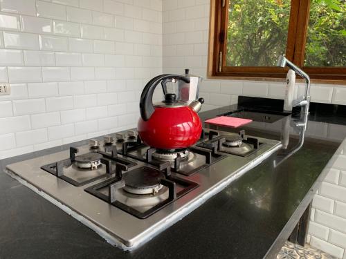 a red tea kettle on a stove in a kitchen at Casa Verde in Valparaíso