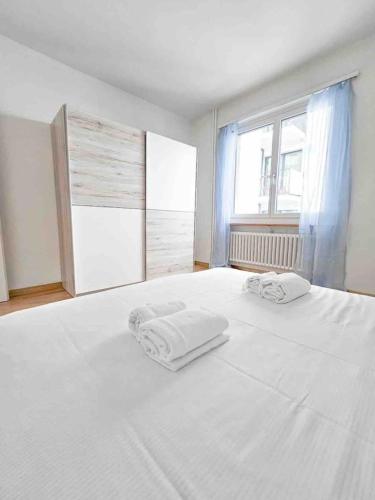 a white bedroom with two towels on a bed at Downtown Dream 3,5BR with Balcony and Style BA31 in Zürich